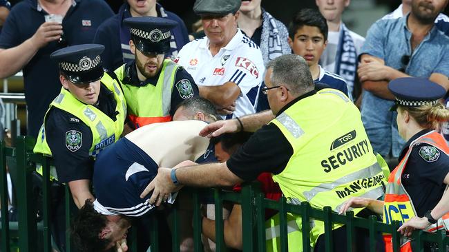 Police tackle a Melbourne Victory fan and escort him out of a game at Adelaide Oval. Picture: Sarah Reed.