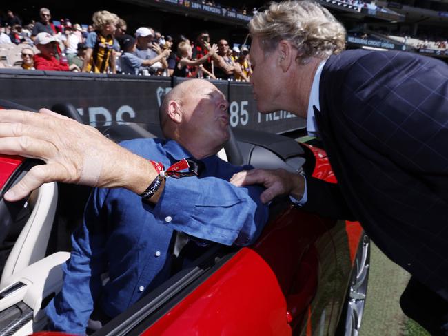 Billy Duckworth and Dermott Brereton re-enact the famous kiss from the 80s at the MCG. Picture: Michael Klein