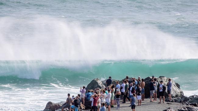 Spectators watch surfers at Kirra as tropical cyclone Oma brings big swell. Picture by Luke Marsden.