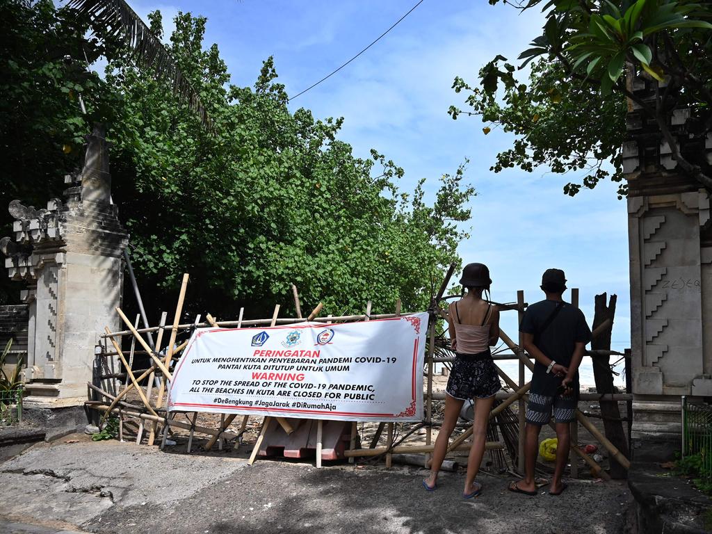 Foreign tourists near a closed beach in Kuta on May 29. Picture: Sonny Tumbelaka/AFP