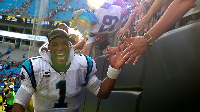 Cam Newton #1 of the Carolina Panthers high fives fans.