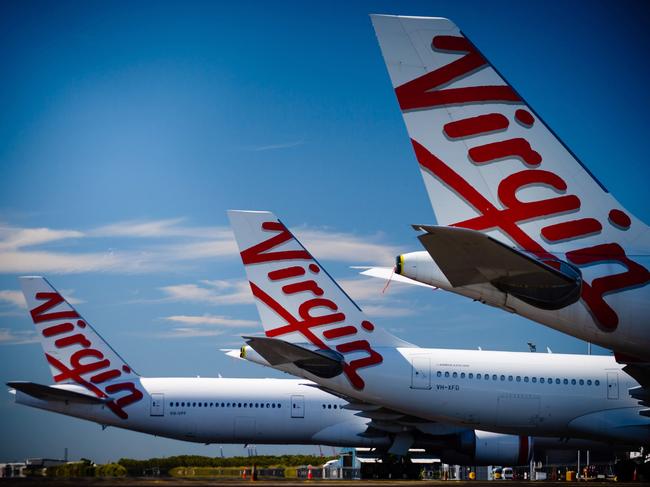 Virgin Australia aircraft are seen parked on the tarmac at Brisbane International airport on April 21, 2020. - Cash-strapped Virgin Australia collapsed on April 21, making it the largest carrier yet to buckle under the strain of the coronavirus pandemic, which has ravaged the global airline industry. (Photo by Patrick HAMILTON / AFP)