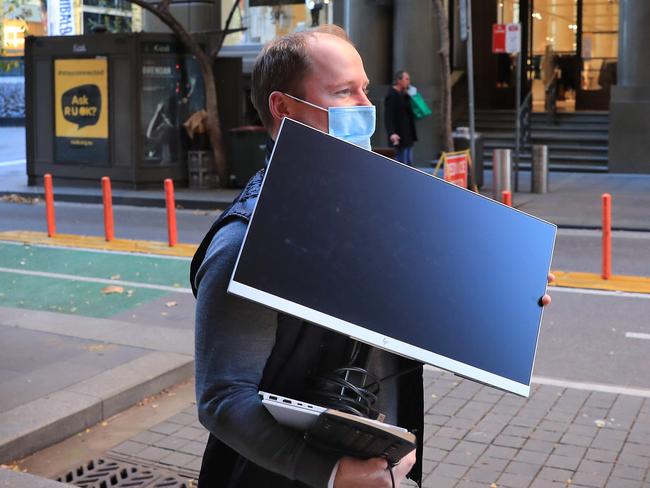 25/6/21: Brett  Scallan takes his computer home so he can work from home as Sydney CBD prepares to go into lockdown for a week after a spike in Covid cases. John Feder/The Australian.