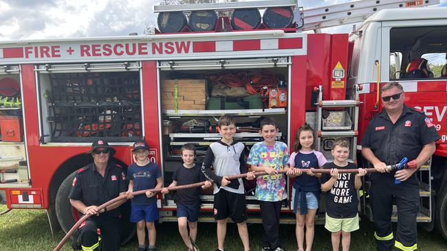 Firefighter Kenny Harrison, Ashton Smith, Riley Nash, Jarrah Robinson, Ryder Davies, McKenzie Robinson, Dexter Robinson and Firefighter Dean Wilson (left to right) pose in front of the Fire + Rescue NSW truck for the 120th Murwillumbah Show. Picture: David Bonaddio