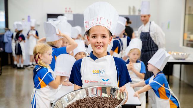 Lucy Sanderson with local Girl Guides preparing food at FareShare, Morningside. PICTURES: AAP/Richard Walker