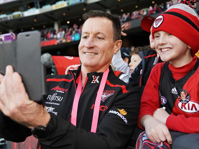 MELBOURNE, AUSTRALIA - JULY 06: Bombers head coach John Worsfold celebrates the win with fans with a selfie during the round 16 AFL match between the Essendon Bombers and the Sydney Swans at Melbourne Cricket Ground on July 06, 2019 in Melbourne, Australia. (Photo by Michael Dodge/Getty Images)