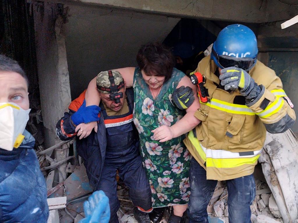 Rescuers help a woman to leave a residential building damaged after a strike in Zaporizhzhia, amid the Russian invasion of Ukraine. Picture: AFP