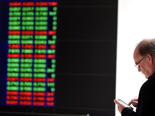 A man watches the ASX trading board in Sydney on Tuesday, Aug. 25, 2015. After an initial 1.5 per cent plunge, the S&P/ASX 200 and the All Ordinaries which pulled both indices below 5,000 points, a recovery among key heavyweight bank stocks pushed the market back into positive territory. (AAP Image/Paul Miller) NO ARCHIVING