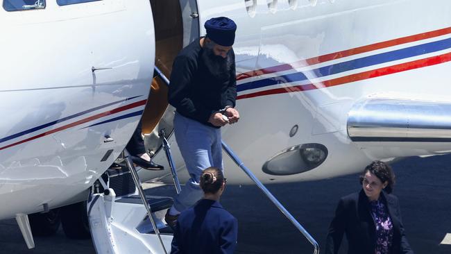 Queensland Police officers and detectives escort Rajwinder Singh from a chartered jet to a waiting police car at Cairns Airport. Picture: Brendan Radke