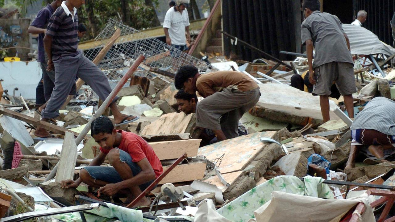 Sri Lankan survivors search through wreckage of homes and businesses following the tsunami.