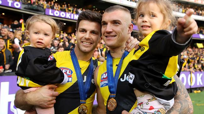 Trent Cotchin of the Tigers and Dustin Martin of the Tigers pose with Cotchins daughters