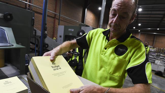 A worker handles a stack of the 2018-19 Budget papers at Canprint in Canberra. Picture: AAP