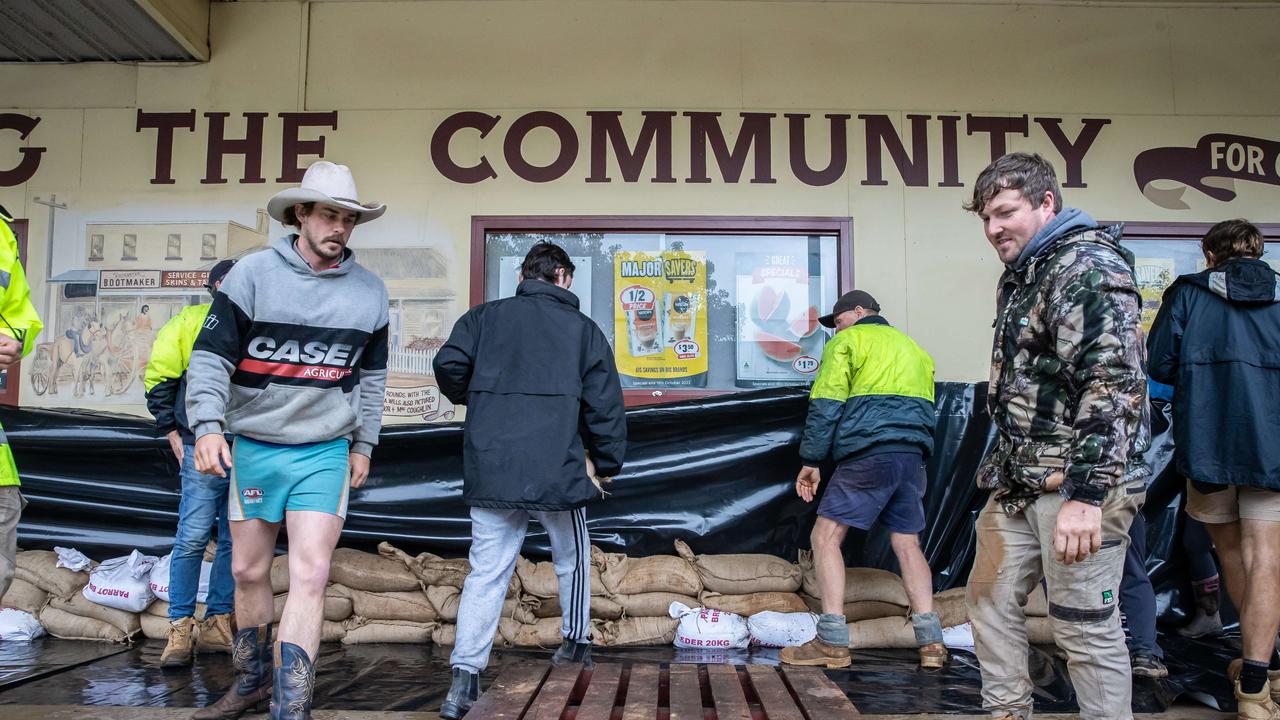 Community members help sandbag and waterproof shopfronts. Picture: Jason Edwards