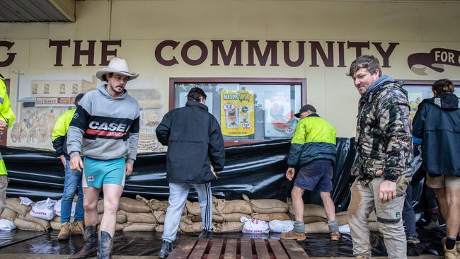 Community members help sandbag and waterproof shopfronts. Picture: Jason Edwards