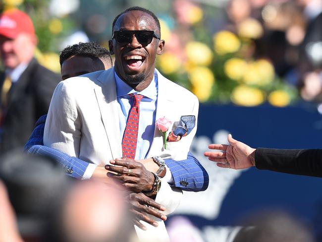 Usain Bolt is hugged by former Australian Olympian John Steffensen at Flemington. Picture: AAP Image/Julian Smith