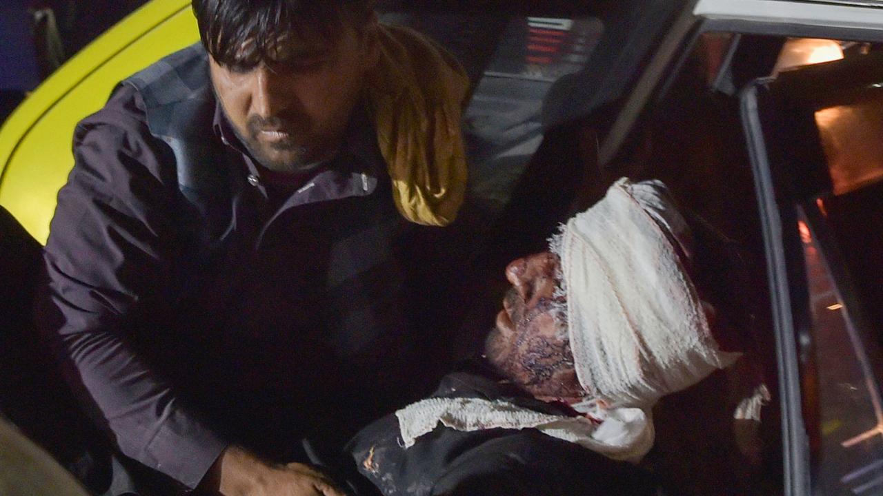 Medical and hospital staff carry an injured man out of a car for treatment. Picture: Wakil Kohsar/AFP