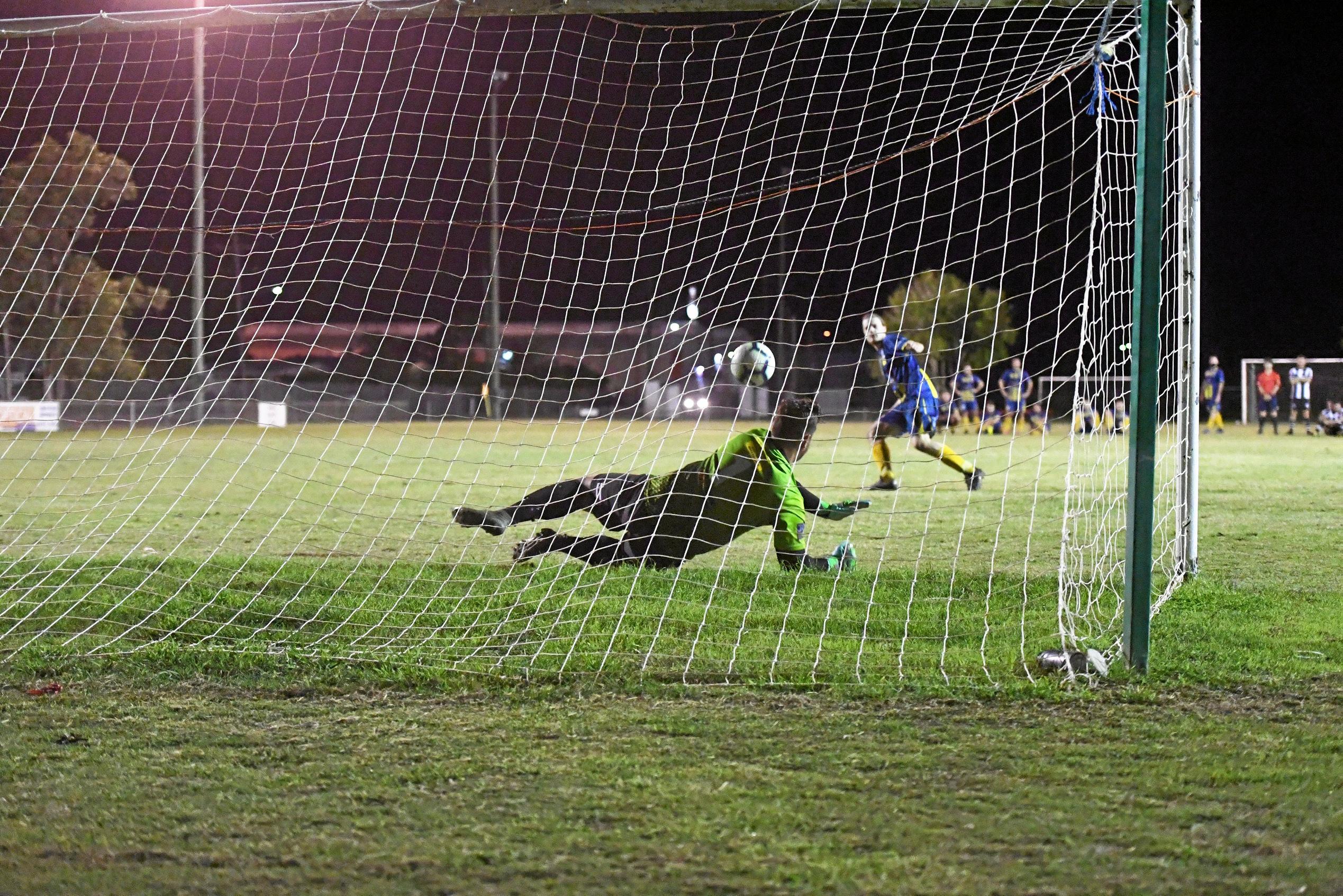 Bingera's Jason McEwan makes a save during the penalty shootout. Picture: Shane Jones