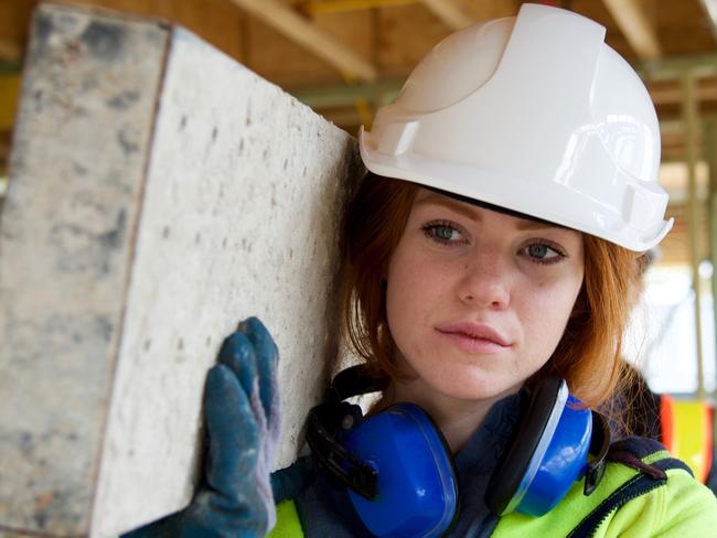 View of a female construction worker portrait working onsite moving scaffold