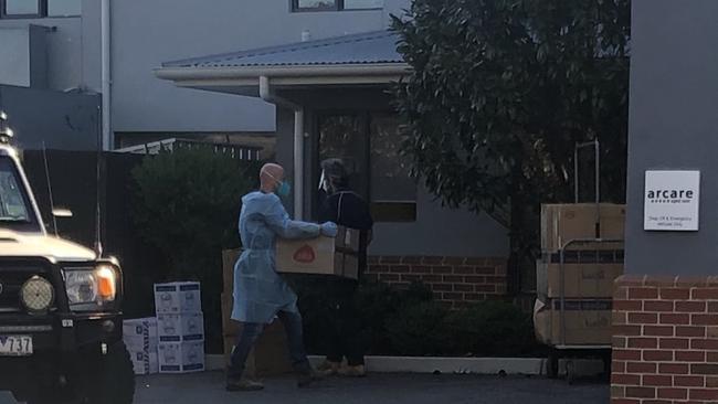 Workers take supplies into the Arcare aged care home in Maidstone. Picture: Remy Varga