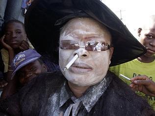  A Haitian woman in a trance smokes a cigarette through her nose during a voodoo ceremony for the day of the dead in the ceme...