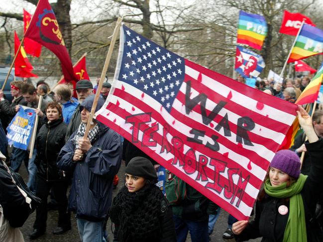 Protesters march through the centre of Amsterdam, in the Netherlands, Mar 20, 2004, in a demonstration to mark the first anniversary of the US-led invasion of Iraq. (AP PicBas/Czerwinski) demonstrations o/seas peace rally american flag "War is Terrorism" written on flag demonstrators peace rally