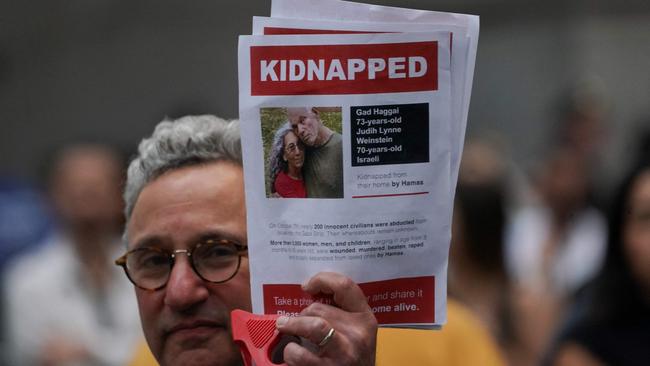 A supporter of Israel holds a picture of kidnapped Israeli hostages Gad Haggai and Judith Weinstein Haggai during a rally in New York. Picture: AFP.