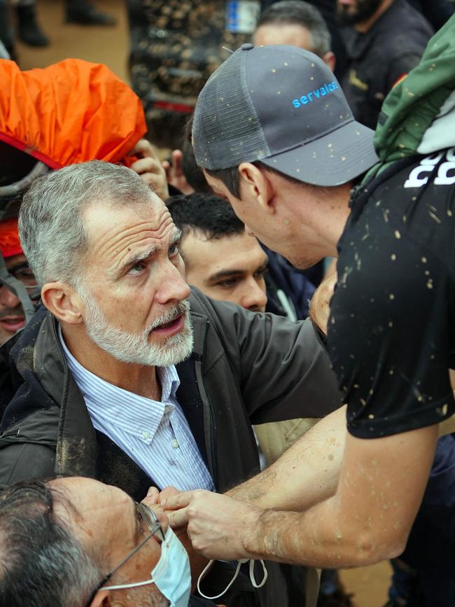 King Felipe was confronted by a local as some in a heaving crowd of protesters hurled mud. Picture: AFP