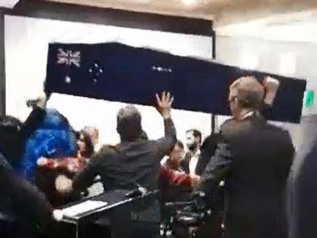 Far-Right protesters storm a Moreland council meeting, carrying a fake coffin painted with the Australian flag. Picture: Emma Hastings