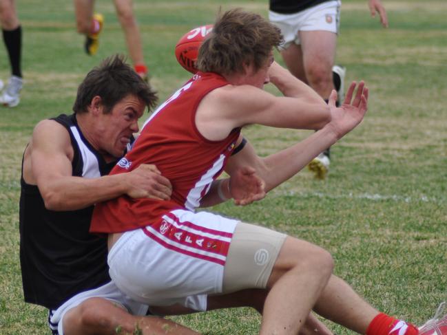 Country football - Crystal Brook vs Jamestown-Peterborough match at Jamestown. Footballer Adam Kupsch handballs as Greg Farr tackles.