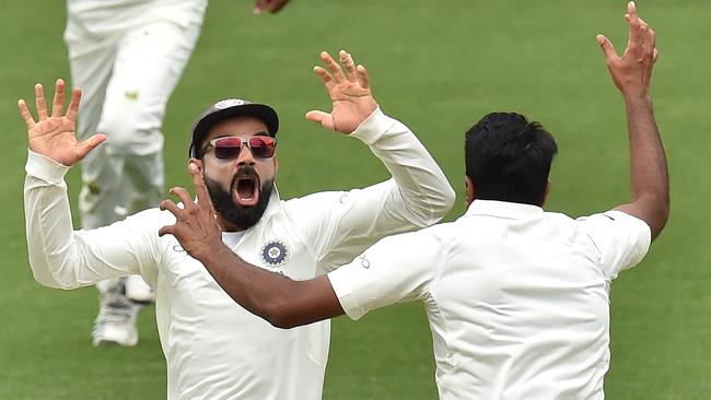 Virat Kohli celebrates with Ravi Ashwin after beating Australia on day five of the first Test in Adelaide in December 2018. Picture: Peter Parks/AFP