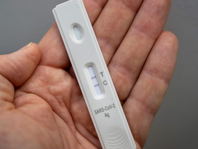 A used rapid antigen test, also known as a lateral flow test showing a positive test result for the Covid-19 coronavirus is photographed in Berlin on January 22, 2022. - Taking a test involves doing swab from inside your nostril or in your throat, depending on the test you are using, before mixing the swab with solution and dripping it onto a container with a test strip with antibodies specific to the Covid-19 virus painted on it in a thin line. If the testing strip detects the virus, it shows up as a red line next to the âTâ on the container, the line next to the âCâshould always be visible. (Photo by Odd ANDERSEN / AFP)