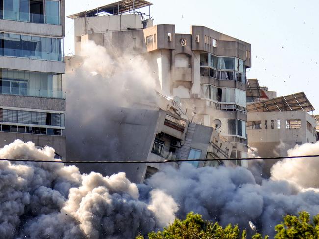 TOPSHOT - This picture shows the moment a building collapses after an Israeli airstrike on Beirut's southern Ghobeiry neighbourhood on November 15, 2024, amid the ongoing war between Israel and Hezbollah. More than a year of clashes that recently escalated into war have cost Lebanon more than $5 billion in economic losses, with actual structural damage amounting to billions more, the World Bank said on November 14. (Photo by IBRAHIM AMRO / AFP)