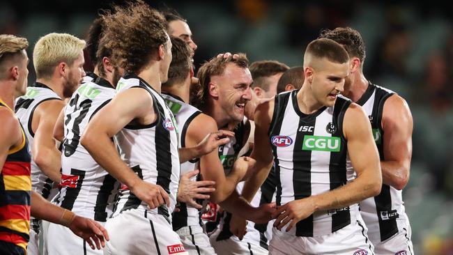 Lynden Dunn is mobbed by teammates after kicking a goal on his Collingwood return.