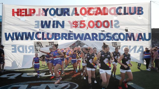 Western Bulldogs and Carlton players run through a joint banner for the Pride Game. Picture: AFL Media