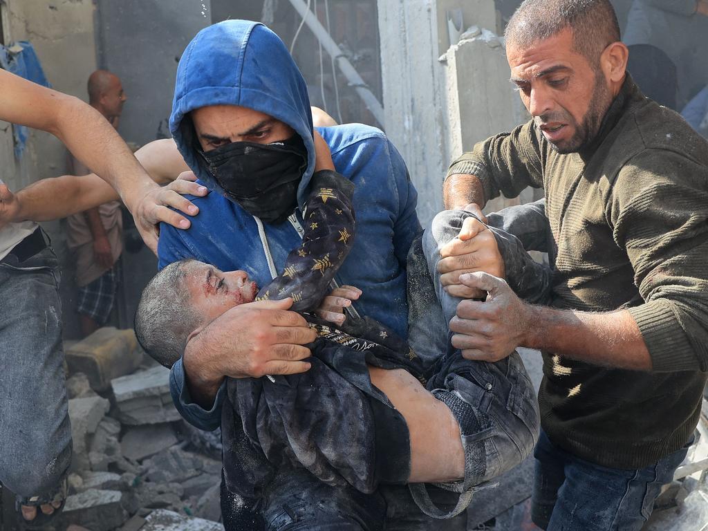 A Palestinian man carries a victim of an Israeli bombardment in Rafah in the southern Gaza Strip on November 7, 2023. Picture: AFP