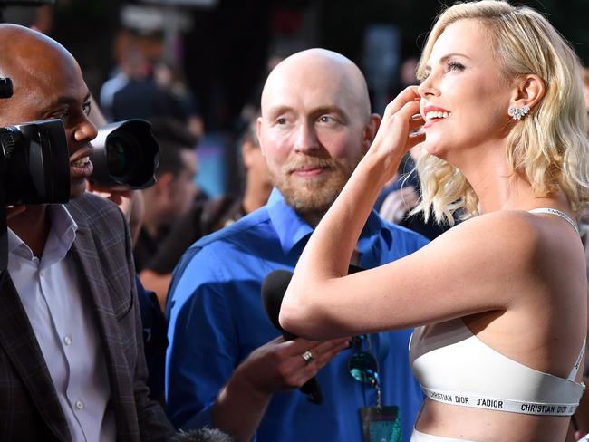 Charlize Theron speaks with journalists as she arrives on the red carpet.