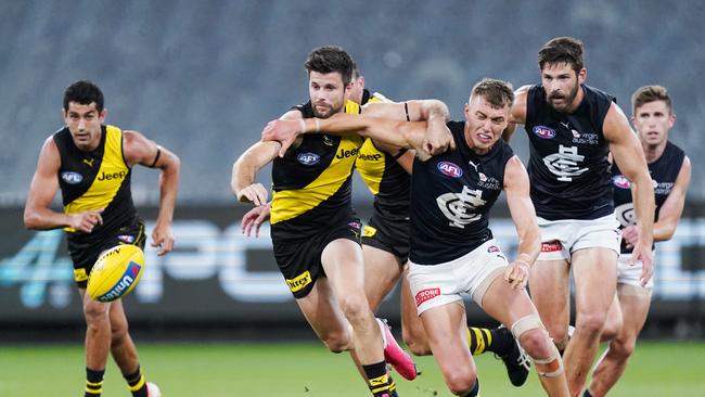 Trent Cotchin of the Tigers competes for the ball against Patrick Cripps of the Blues during the Round 1 AFL match between Richmond and Carlton at the MCG in Melbourne, Thursday, March 19, 2020. (AAP Image/Michael Dodge) NO ARCHIVING, EDITORIAL USE ONLY