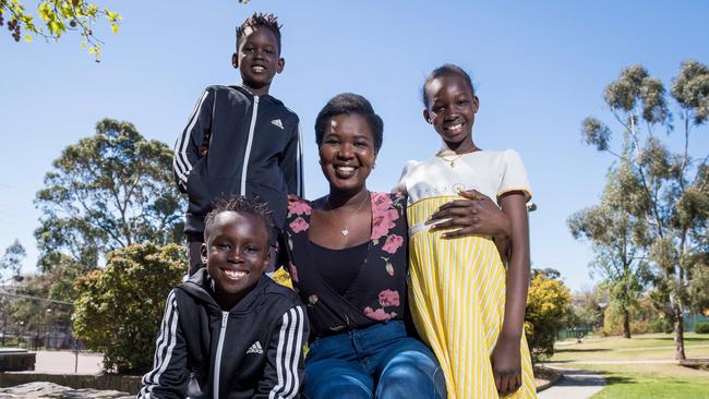 Aguer Athian with Breakfast Club kids Nyol, 7, Makuch, 5, and Sienna, 9. Picture: Jake Nowakowski