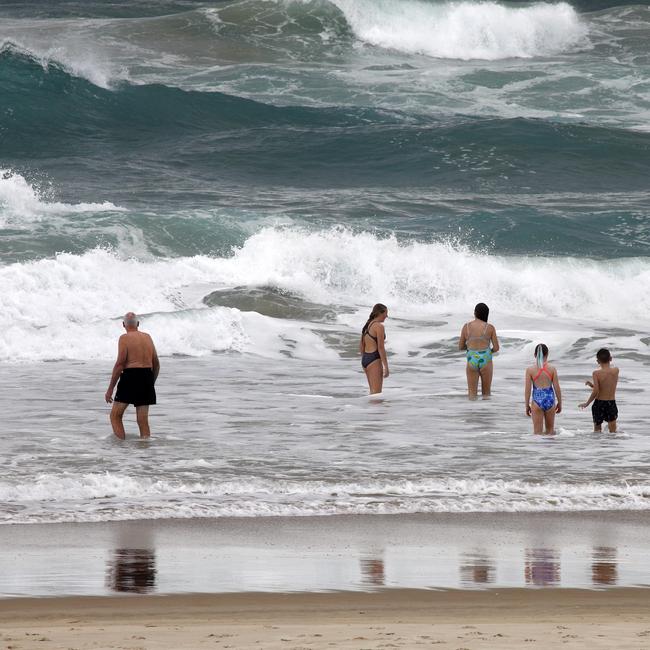 Day 2 in lockdown. Swimmers in the waves at Broadbeach. Picture: Tertius Pickard