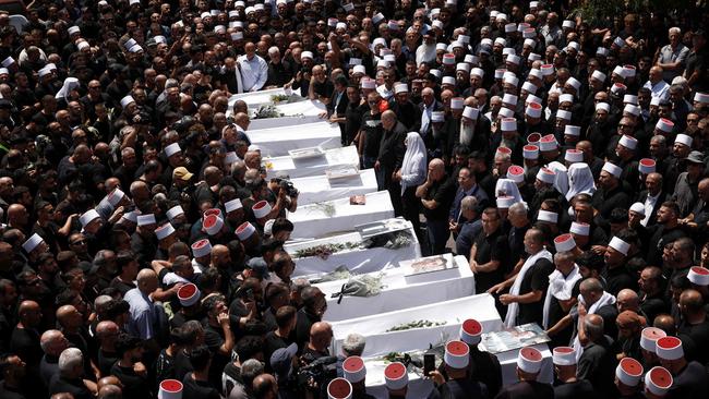 Druze elders and mourners surround the coffins of 10 of the 12 people children and young people killed in a rocket strike from Lebanon in July. Picture: AFP