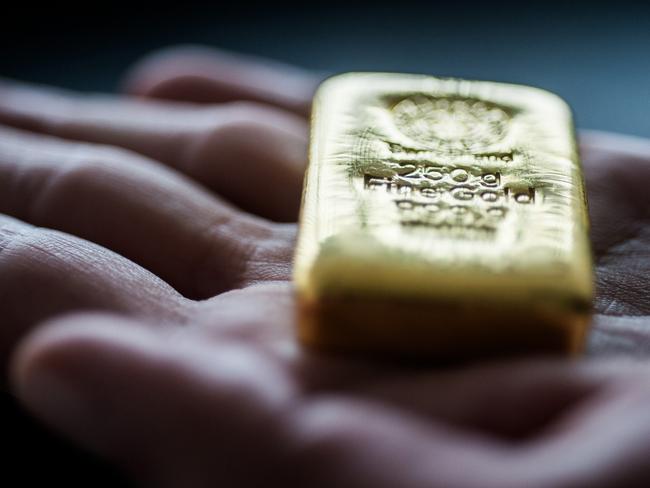 An employee holds a two hundred and fifty gram gold bar in this arranged photograph at Solar Capital Gold Zrt. in Budapest, Hungary, on Thursday, March 10, 2016. Gold advanced to the highest level in a year after the European Central Bank indicated it wouldn't cut interest rates further, boosting the euro and making dollar-denominated bullion less expensive for investors. Photographer: Akos Stiller/Bloomberg