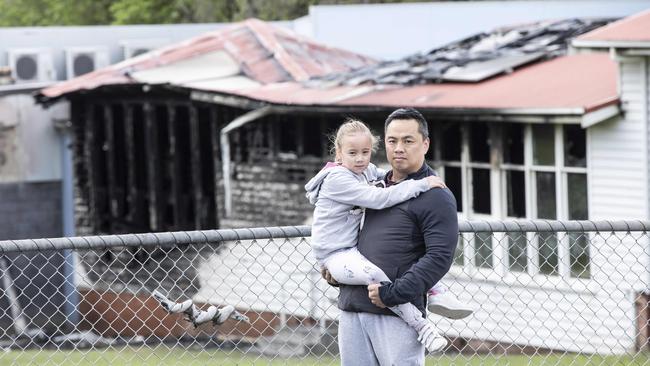 7 year old Grade 2 Bowen Road Primary School student Piper Su and her Dad Tony Su looking over their fire damaged school.