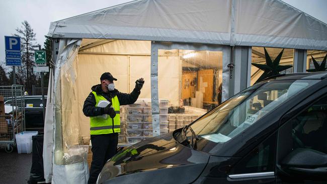 A man prepares PCR test kits to be collected by Taxi Stockholm drivers at a station to deliver them to people who suspect they have COVID-19. Picture: Jonathan Nackstrand/AFP