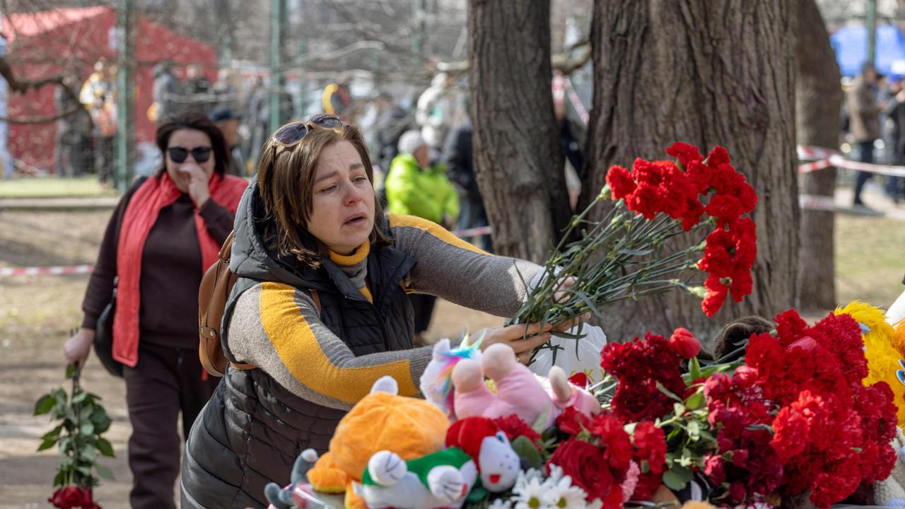 People react as they lay flowers in front of toys displayed outside a multi-story building heavily damaged in Odessa amid the Russian invasion of Ukraine. Picture: AFP