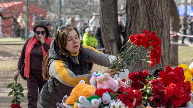 People react as they lay flowers in front of toys displayed outside a multi-story building heavily damaged in Odessa amid the Russian invasion of Ukraine. Picture: AFP