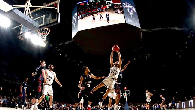 Shea Ili of United rebounds the ball in front of Dan Dillon at the Entertainment Centre. Picture: Kelly Barnes (AAP).