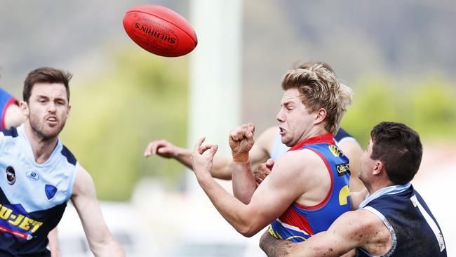 Huonville's Jack Howarth handballs while being tackled in the SFL preliminary final between Huonville v Lindisfarne. Picture: Zak Simmonds