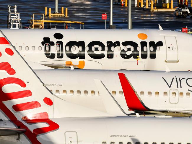 Planes from Australian airlines Tiger Air and Virgin sit idle on the tarmac at Melbourne's Tullamarine Airport on April 12, 2020. - Confinement measures taken around the globe to slow the coronavirus outbreak have forced millions of people to abandon travel plans and stay home, bringing the airline industry to its knees. (Photo by William WEST / AFP)