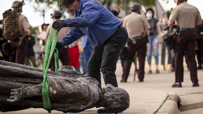 A statue of Christopher Columbus, which was toppled to the ground by protesters, is loaded onto a truck in St Paul, Minnesota. Picture: AFP