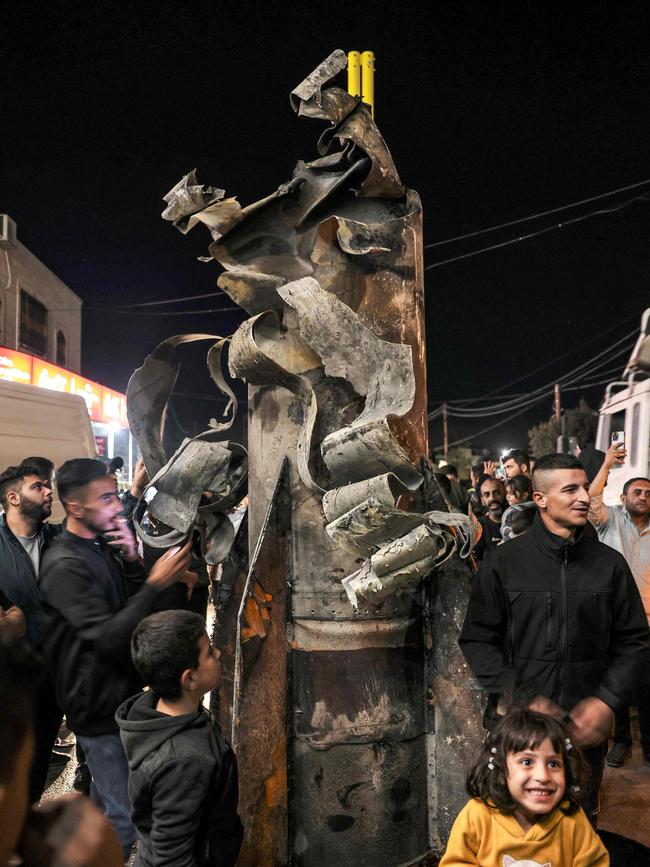 People gather around a fallen projectile that was moved in the Palestinian village of Dura west of Hebron after Iran launched a barrage of missiles at Israel. Picture: Hazem Bader/AFP